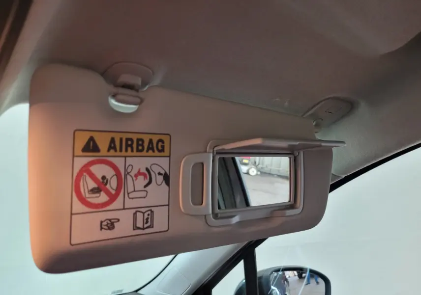 Détail du pare-soleil côté conducteur avec miroir et avertissement airbag dans une Renault Clio gris foncé.