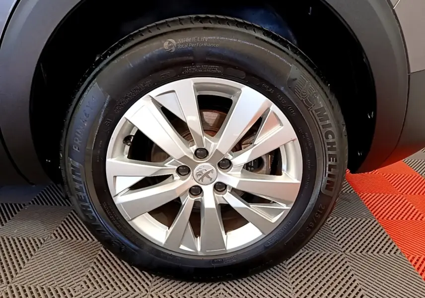 Gros plan sur la roue avant droite gris clair du Peugeot 5008 avec jante alliage et pneu Michelin.