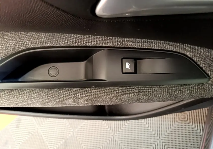 Gros plan sur la commande de lève-vitre côté porte intérieure avec revêtement tissu gris du Peugeot 5008 gris clair.