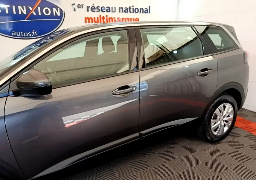 Profil côté gauche d’un Peugeot 5008 gris clair 2021, avec rétroviseurs électriques et jantes alliage visibles.