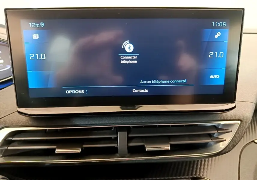 Écran tactile central bleu affichant la connexion Bluetooth, avec les aérateurs noirs en dessous, intérieur Peugeot 5008 gris clair.