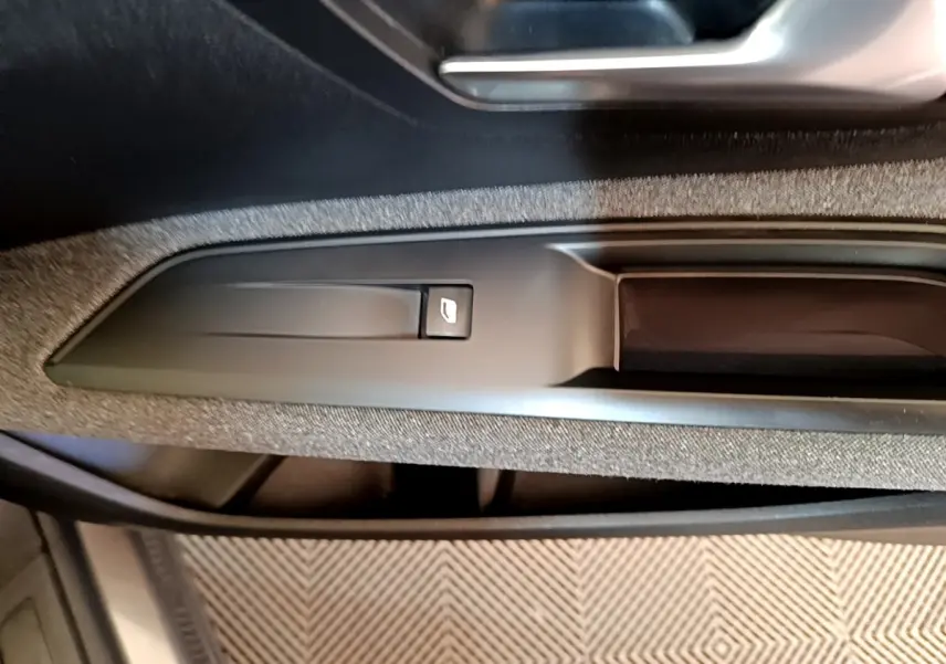Gros plan sur la commande de lève-vitre côté conducteur dans l’habitacle gris du Peugeot 5008 2021.