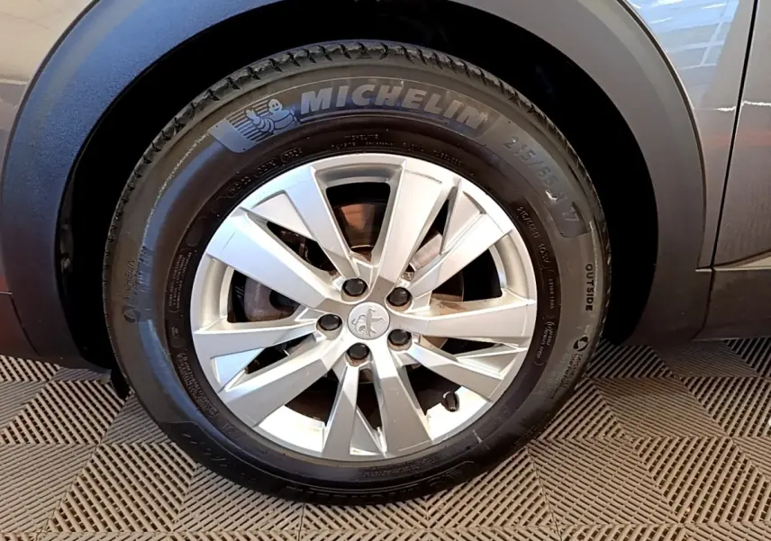 Gros plan sur la roue avant droite grise du Peugeot 5008 avec jante alliage et pneu Michelin visible.