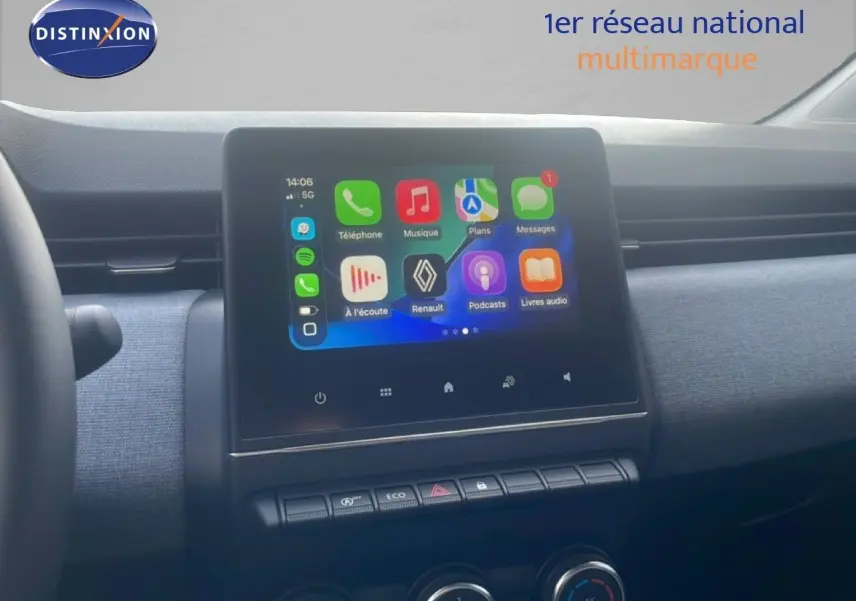 Vue intérieure centrée sur l’écran tactile multimédia de la Renault Clio blanche 2025 avec tableau de bord gris et commandes climatisation.