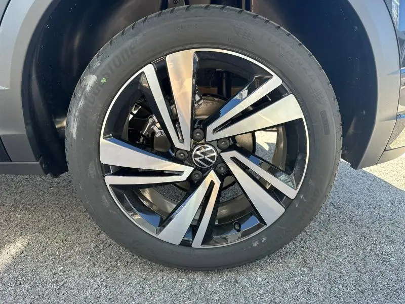 Gros plan sur la jante alu bicolore noire et argentée du Volkswagen T-Roc 1.5 TSI Evo2 2025, avec logo VW central.