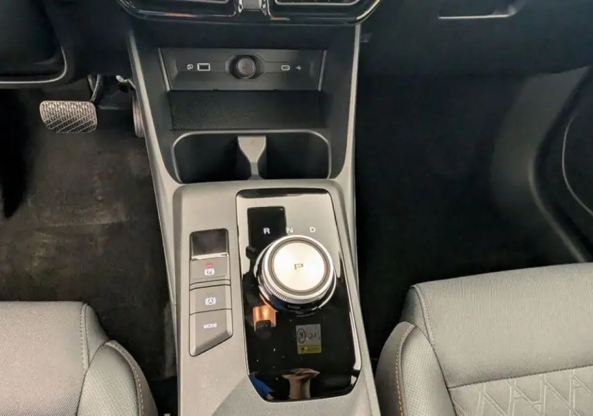 Vue plongeante sur la console centrale du MG3 1.5 HYBRID+ 195 LUXURY 2026 avec molette de boîte auto et sièges gris.