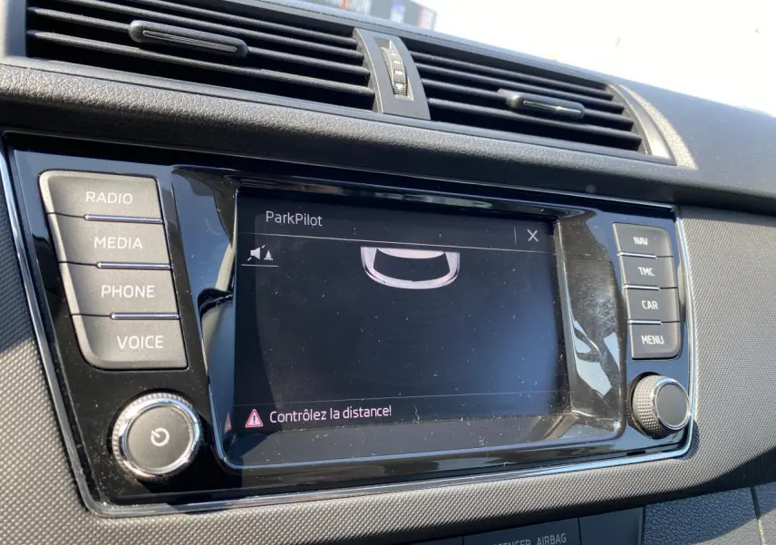 Écran tactile central du système ParkPilot dans une Skoda Fabia blanche, avec boutons de commande autour.