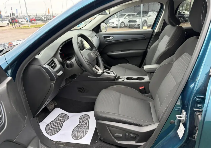 Vue intérieure côté conducteur de la Renault Arkana 2025 bleu Zanzibar, avec sièges gris et volant multifonction.