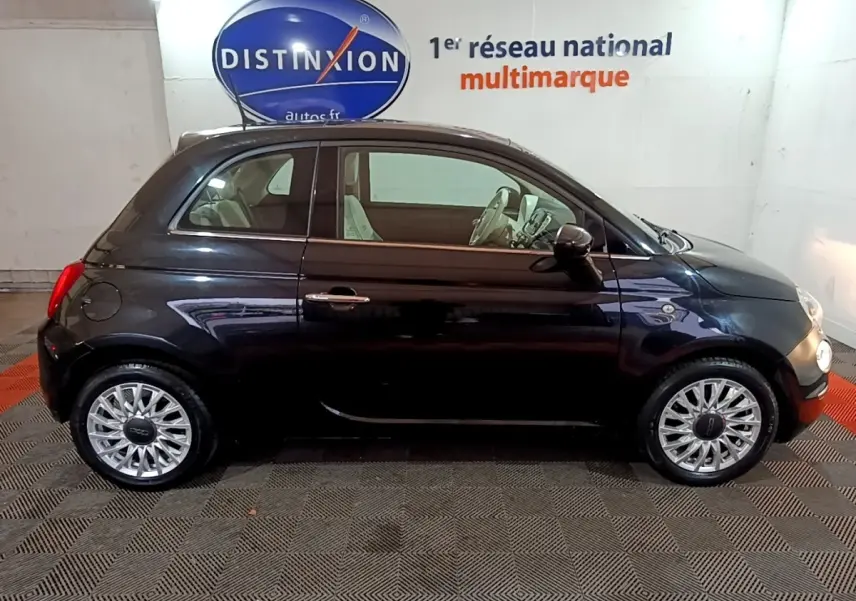 Profil droit d'une Fiat 500 noire 2019, avec jantes alliage et intérieur clair visible en showroom.
