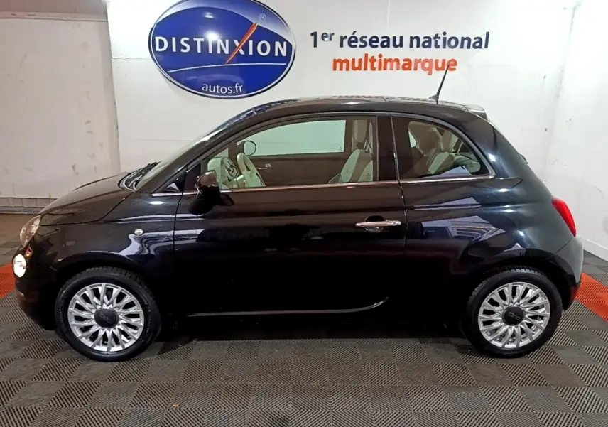 Profil côté gauche d'une FIAT 500 Lounge noire 2019, avec jantes alliage et intérieur clair visible.