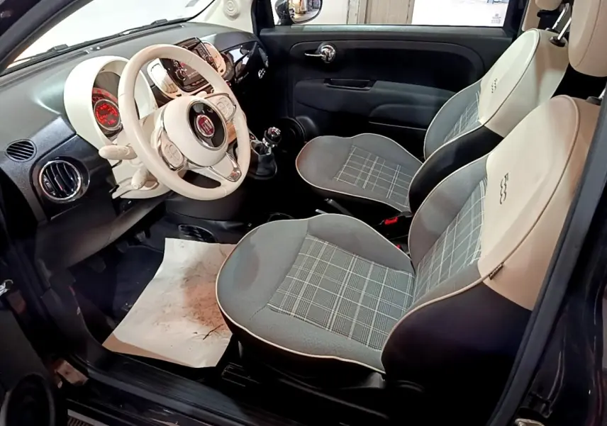 Intérieur de la FIAT 500 Lounge 2019 vu côté conducteur, sièges bicolores gris et beige avec volant cuir blanc.