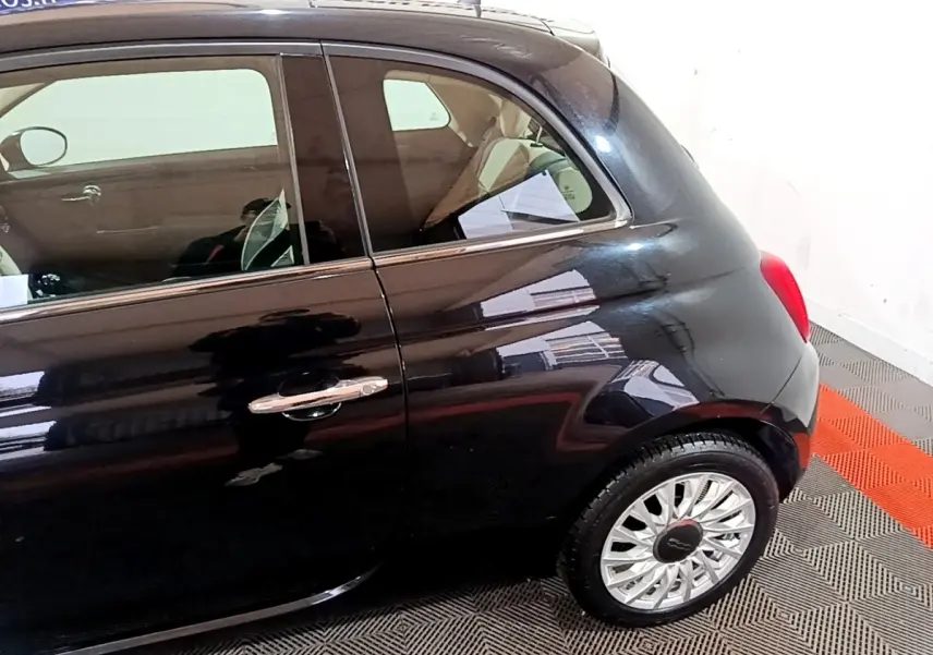 Vue côté droit arrière d'une FIAT 500 noire 2019 avec jante alliage et poignée de porte chromée.
