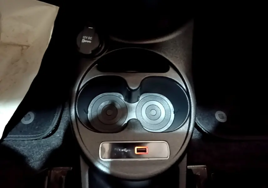 Gros plan sur la console centrale noire de la Fiat 500 Lounge 2019 avec porte-gobelets et prise USB rouge.
