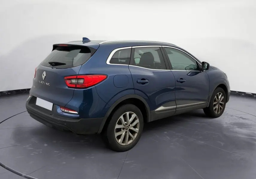 Vue arrière d’un Renault Kadjar bleu cosmos 2020 avec coffre ouvert montrant l’espace de chargement vide.