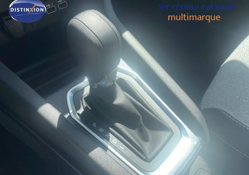 Gros plan sur le levier de vitesses automatique noir de la Renault Clio blanche, version 2025, intérieur tissu noir.