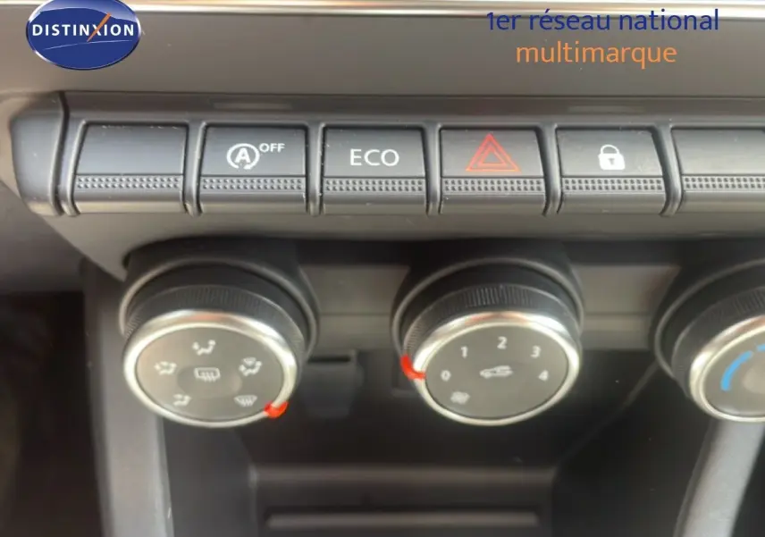 Gros plan sur les commandes de climatisation et boutons fonctionnels du tableau de bord d’une Renault Clio blanche 2025.