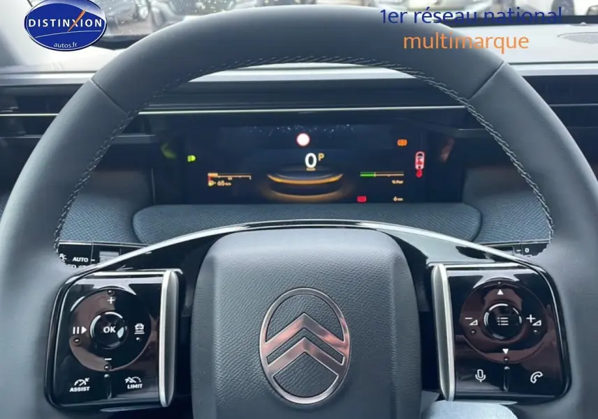 Vue rapprochée du volant noir multifonction avec logo Citroën et tableau de bord numérique du C5 Aircross hybride 2026.