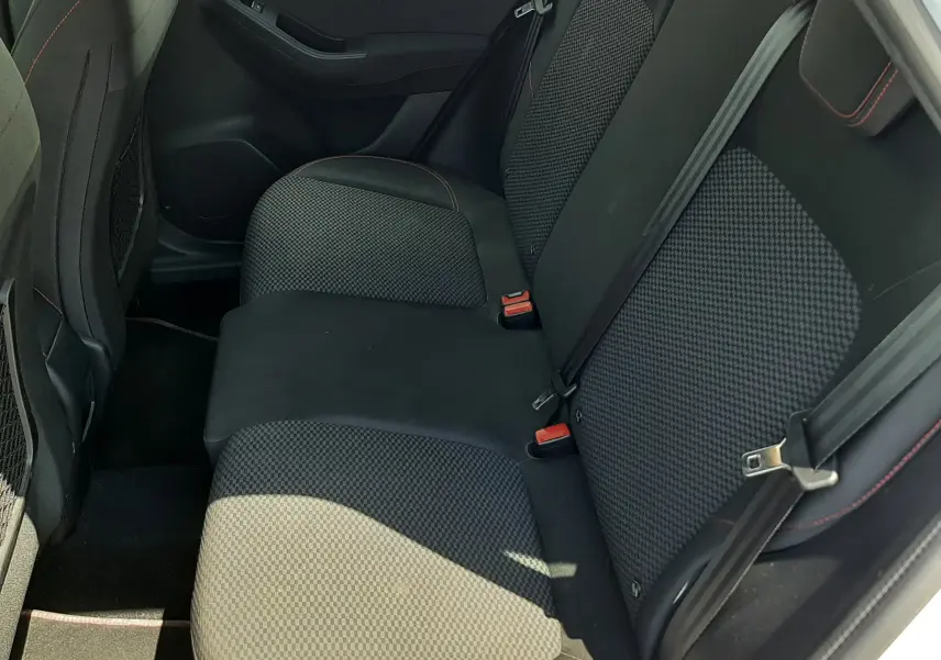 Vue intérieure côté droit des sièges arrière noirs avec surpiqûres rouges du Ford Puma blanc 2022 finition ST-Line.