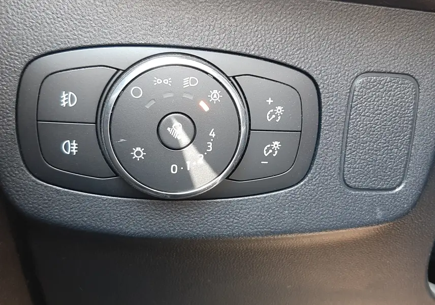 Gros plan sur la molette de réglage des phares du Ford Puma blanc, avec commandes d’éclairage et de réglage d’intensité.