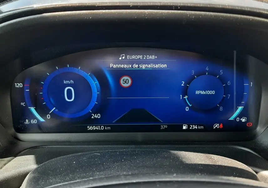 Tableau de bord numérique bleu du Ford Puma 2022, affichant vitesse à 0 km/h et panneau signalisation 50 km/h.