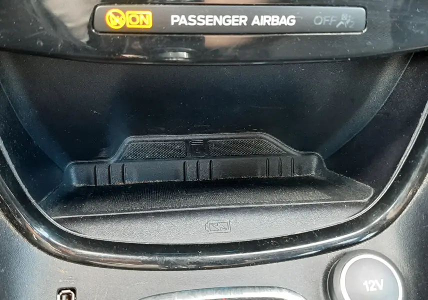 Détail intérieur du Ford Puma 2022 montrant l'indicateur airbag passager activé, prise USB, prise 12V et console noire avec surpiqûres rouges.