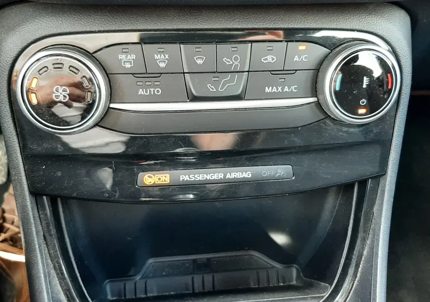 Gros plan sur la console centrale du Ford Puma 2022, montrant les commandes de climatisation et l'indicateur d'airbag passager.