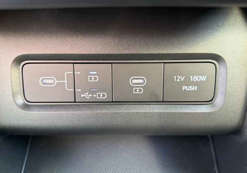 Gros plan sur les ports USB-C et prise 12V 180W du tableau de bord du Hyundai Tucson gris clair 2026.