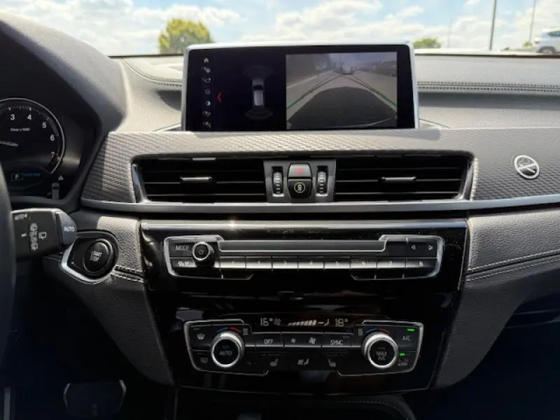 Vue intérieure du tableau de bord du BMW X2 2021, écran central affichant la caméra de recul, finition noire élégante.