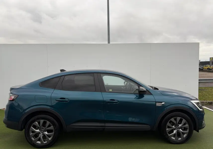 Profil droit du Renault Arkana 2025 bleu Zanzibar métallisé avec jantes alliage grises et vitres surteintées.