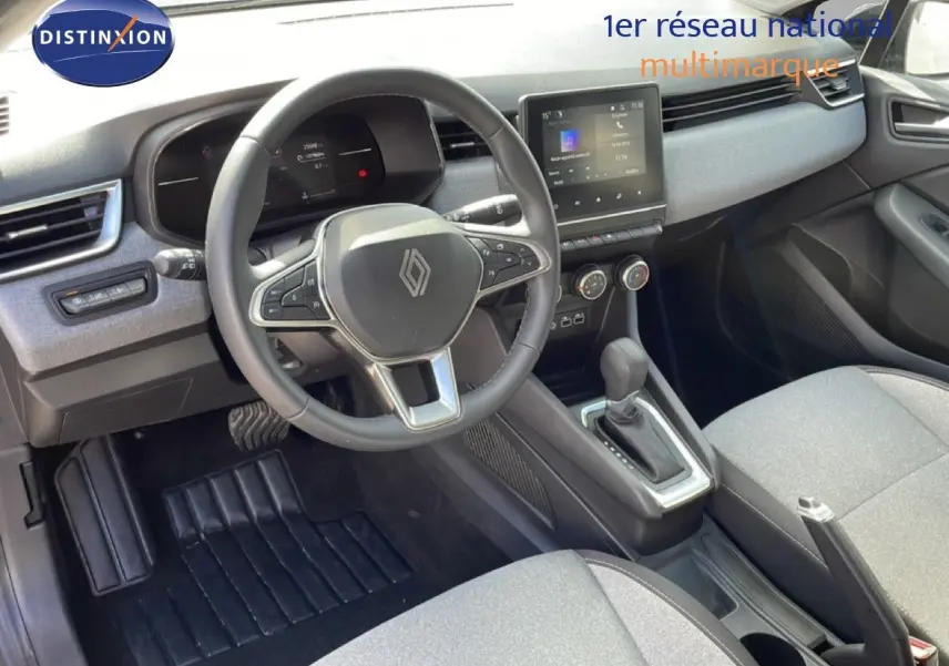 Vue intérieure avant de la Renault Clio 2025 gris schiste métal, avec tableau de bord moderne et boîte automatique.