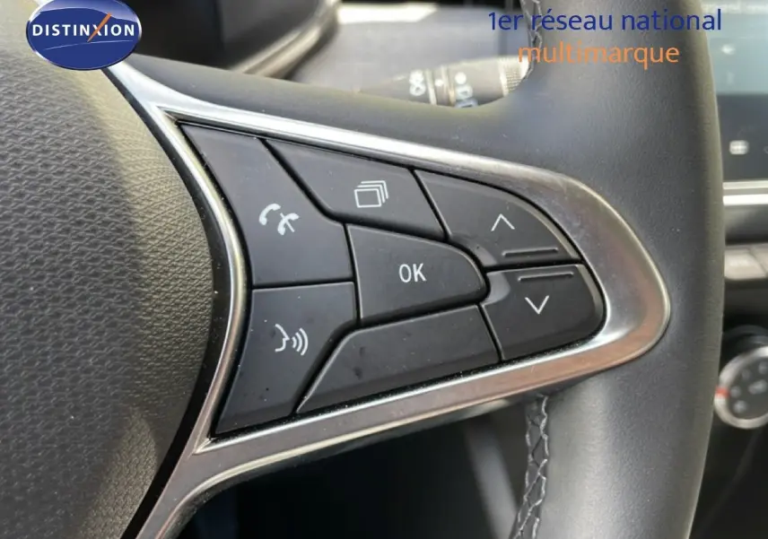 Gros plan sur les commandes multifonctions côté gauche du volant cuir d’une Renault Clio gris schiste 2025.
