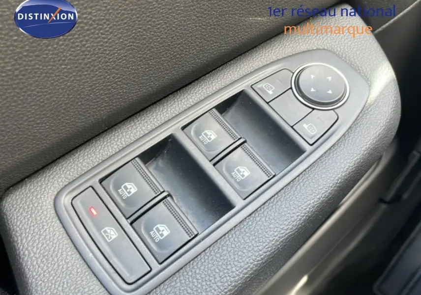 Gros plan sur les commandes de lève-vitres et rétroviseurs côté gauche d’une Renault Clio gris schiste métal 2025.