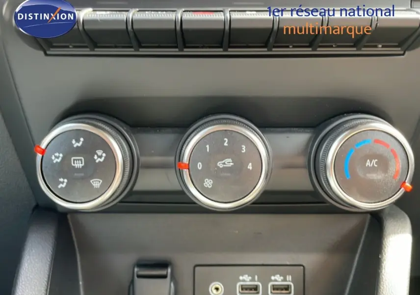 Gros plan sur les commandes de climatisation et les ports USB de la Renault Clio gris schiste métal, version 2025.