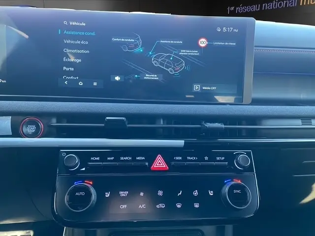 Vue rapprochée de l'intérieur du tableau de bord du Hyundai Tucson noir 2026, avec écran tactile multifonctions et commandes climatisation.