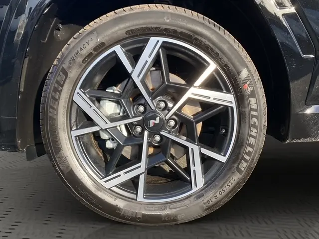Gros plan sur la roue avant droite noire du Hyundai Tucson 1.6 Hybrid N Line 2026 avec jante alliage au design géométrique.