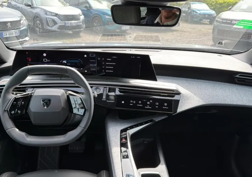 Vue intérieure du tableau de bord et volant cuir multifonction du Peugeot 5008 gris Artense, avec écran tactile panoramique.