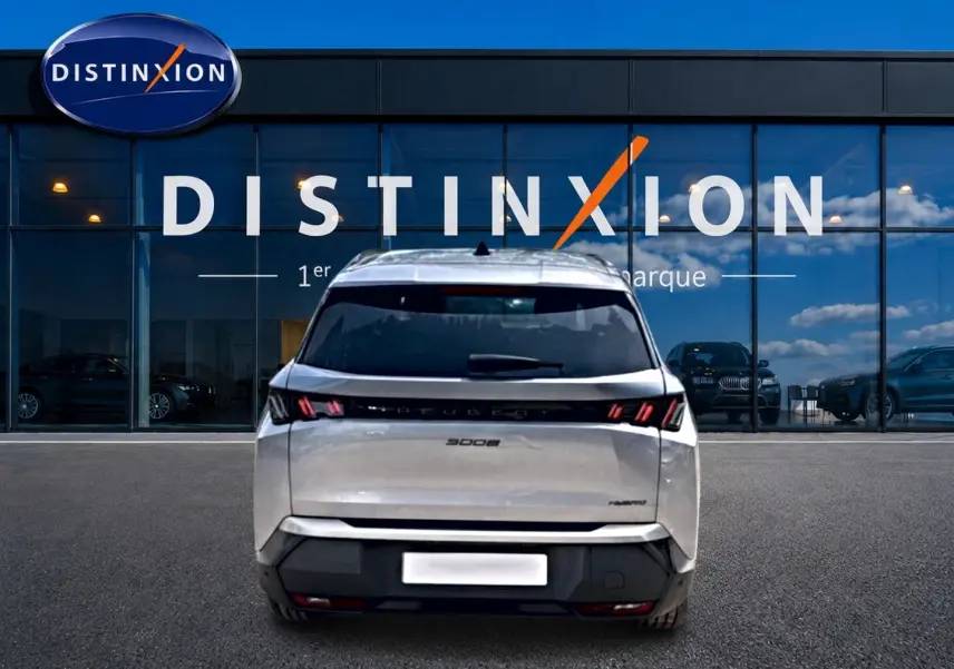 Vue arrière d'un Peugeot 5008 gris Artense avec feux LED caractéristiques, stationné devant une vitrine Distinxion.