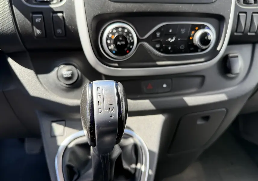 Gros plan sur le levier de vitesse automatique et la console centrale du Renault Trafic gris, vue intérieure avant.