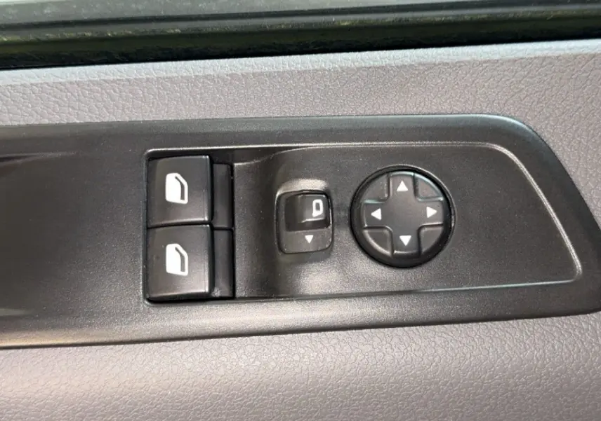 Commandes de réglage des rétroviseurs et des vitres sur la porte intérieure d'un Opel Vivaro Combi gris 2022.