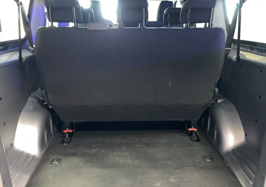 Vue arrière intérieure du coffre spacieux d'un Opel Vivaro Combi gris 2022 avec banquette arrière en tissu noir.
