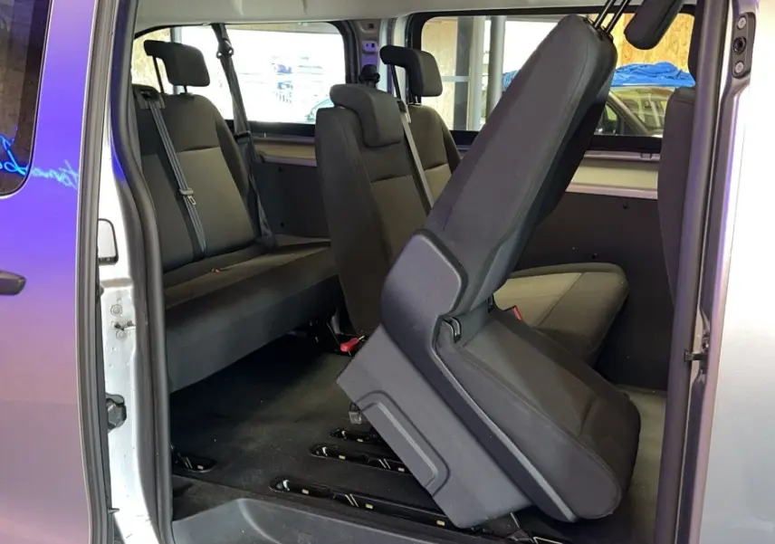 Intérieur du Opel Vivaro Combi gris 2022, vue côté droit sur les sièges en tissu avec un siège relevé au premier plan.