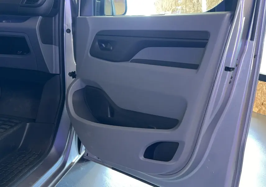 Vue rapprochée de la porte avant droite grise de l'Opel Vivaro Combi 1.5 Diesel 120, intérieur en tissu gris.