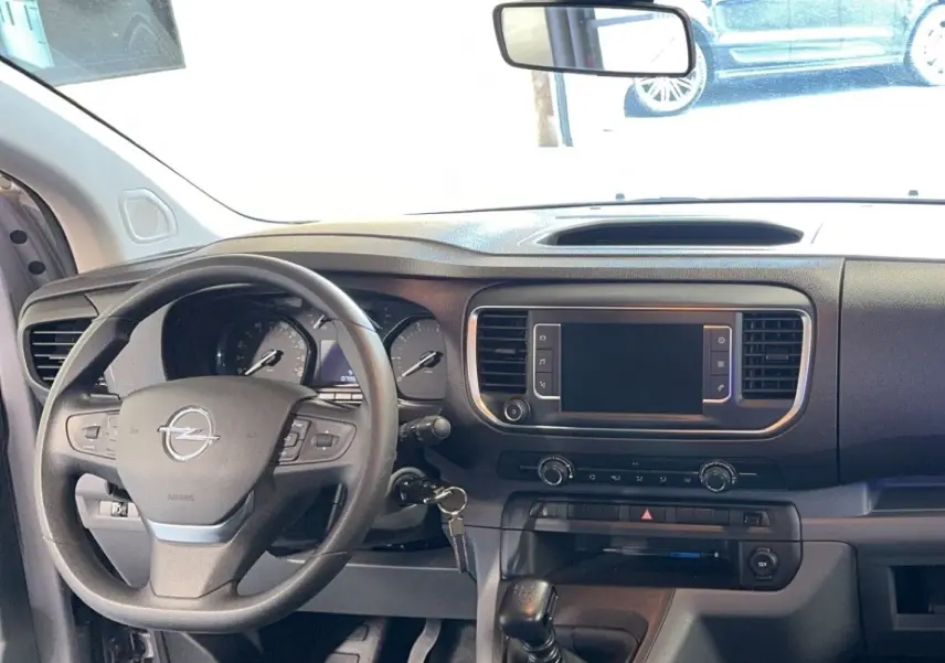 Intérieur de l'Opel Vivaro Combi gris 2022, vue frontale du tableau de bord avec volant multifonction et écran tactile éteint.