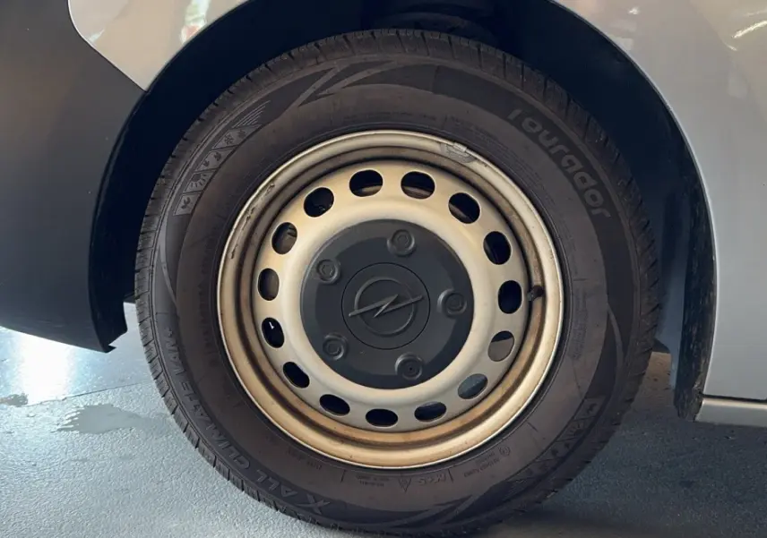 Gros plan sur la roue arrière droite grise d’un Opel Vivaro Combi 1.5 Diesel 120 avec jante acier et logo Opel central.