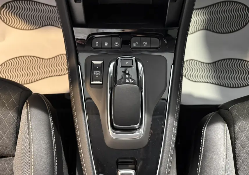 Vue plongeante sur la console centrale noire brillante de l'Opel Grandland X 1.6 Hybrid Turbo avec levier de vitesses automatique.