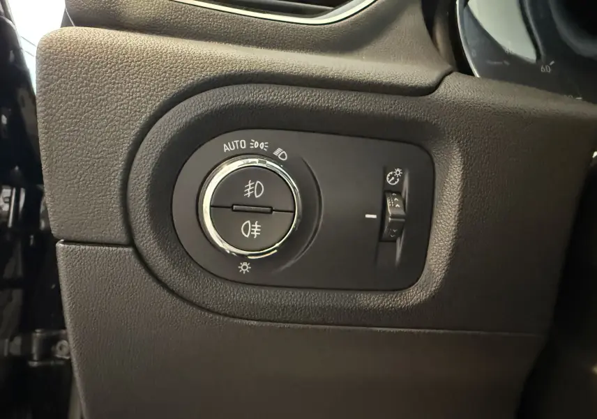 Gros plan sur le sélecteur d'éclairage noir du tableau de bord de l'Opel Grandland X hybride rechargeable 2021.