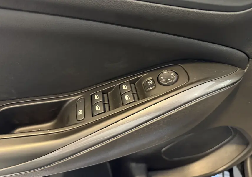 Vue rapprochée de la porte côté gauche de l’Opel Grandland X noir métal, montrant les commandes électriques des vitres et rétroviseurs.