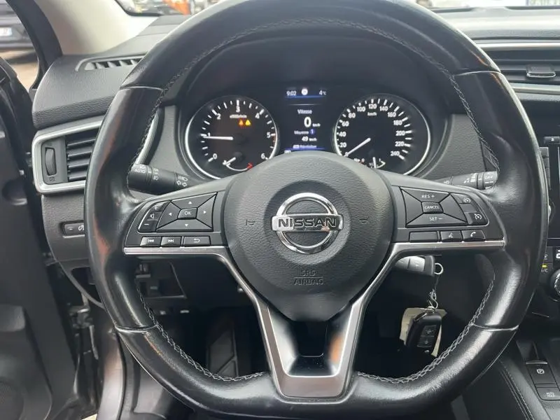 Vue rapprochée du volant cuir multifonction Nissan Qashqai 2020 avec tableau de bord et écran digital allumé.