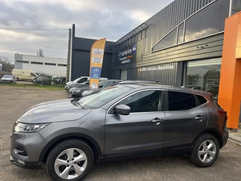 Nissan Qashqai gris Squale vu de profil côté gauche, avec jantes alliage et vitres arrière teintées.