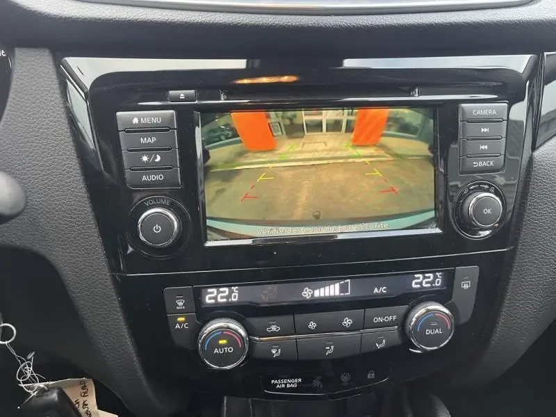 Écran tactile central affichant la caméra de recul du Nissan Qashqai 1.5 dCi gris Squale, avec commandes climatisation bi-zone.